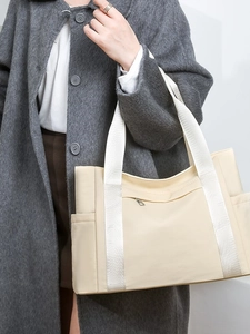 Lightweight beige nylon tote bag with multiple pockets and wide handles for women