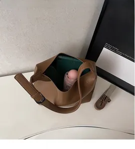 Interior view of brown pebble leather bucket bag showing large capacity for tablet and umbrella