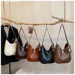 Detailed display of assorted Hobo bags with leopard charms hanging on natural branches