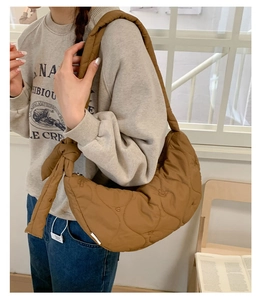 Détail du sac croissant matelassé caramel avec broderie ours et bandoulière nouée