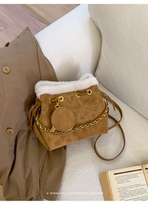 Détail du sac seau en daim marron avec fausse fourrure blanche et motifs en relief rétro