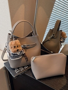 Elephant grey pebbled leather bucket bag set with silver clasp and plush dog charm