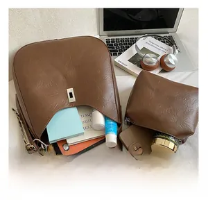 Flat lay of retro brown leather hobo bag set showing large interior capacity with accessories