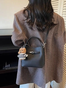 Black pebbled leather bucket bag with silver twist lock and cute teddy bear charm