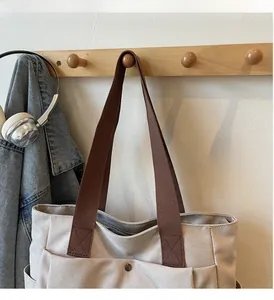 Détail du cabas en toile avec coutures renforcées et bouton-pression rétro