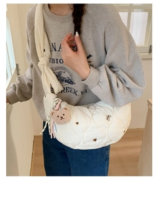 Détail du sac croissant matelassé blanc avec broderie cœur et breloque ourson
