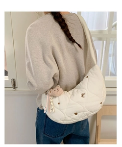 Détail du sac croissant matelassé blanc avec broderie ours et breloque peluche