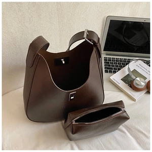 Detail of vintage dark brown hobo bucket bag set with textured leather and hardware clasp