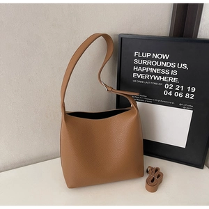 Detailed macro view of high-quality litchi grain leather on a large brown tote bag