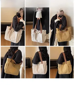 Detail view of large canvas tote bag showing side pockets and dual-tone shoulder straps