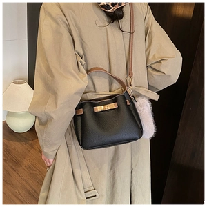 Chic black lychee grain leather tote bag with brown straps and plush ball charm