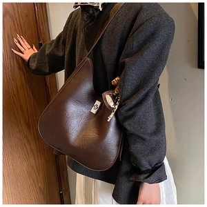 Detail of dark brown pebble leather handbag with silver twist lock and leopard print scarf