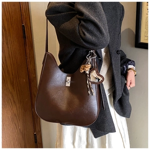 Close-up of brown faux leather shoulder bag featuring silver lock and leopard scarf