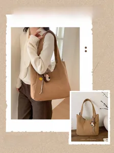 Detailed view of a brown canvas tote bag with C'est la vie text and puppy charm