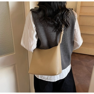 Detailed back view of a light khaki lychee grain leather tote bag styled for commuting