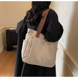 Détail du grand sac cabas en toile avec bandoulières marron et poches fonctionnelles