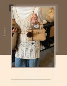 Détail du mini sac seau beige texturé avec sangle en cuir et breloque en peluche