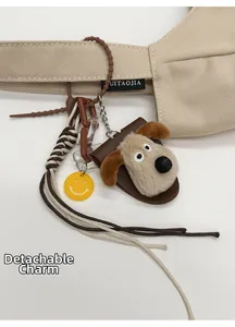 Detail of cute plush puppy charm with leather base and woven rope on a canvas bag