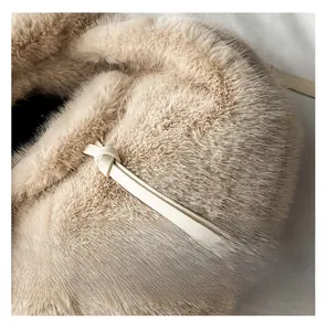 Détail de la texture en fausse fourrure beige avec un nœud décoratif en similicuir
