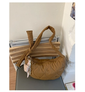 Détail du sac croissant matelassé caramel avec coutures cœur et breloque ours