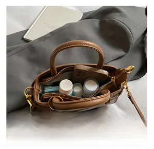 Internal view showing spacious compartments and zip pocket of brown leather bucket bag