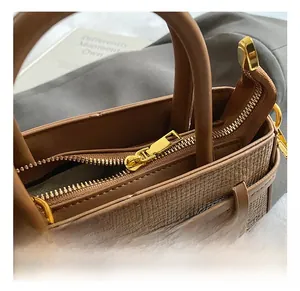 Close-up of golden metal zipper and woven texture on a brown vintage bucket bag