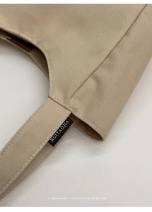 Close-up of premium stitching and canvas texture on a vintage beige bucket bag