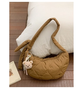 Détail du sac demi-lune marron matelassé avec bandoulière à nœud et ours peluche