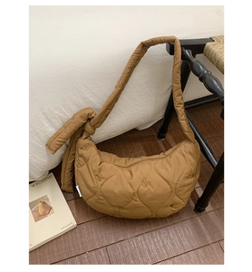 Détail du sac bandoulière matelassé caramel avec broderie d'ours et bandoulière à nœud