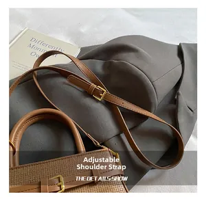 Close-up of brown woven bucket bag with adjustable leather strap and gold hardware