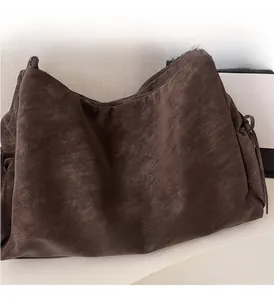 Close-up of vintage dark brown tote bag showing matte texture and embossed brand logo