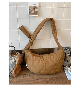 Détail du sac dumpling matelassé caramel avec motifs de cœur et bandoulière nouée