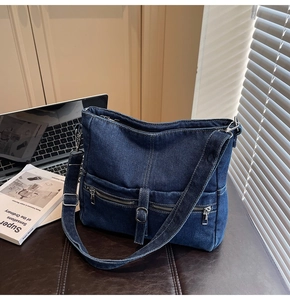 Macro view of dark blue denim tote with double front zippers and metal hardware details