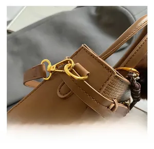 Close-up of golden metal hooks and hardware details on a brown leather bucket bag