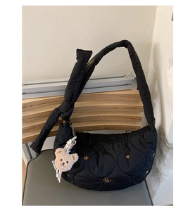 Détail du sac bandoulière noir matelassé avec broderie étoile et pendentif ours peluche