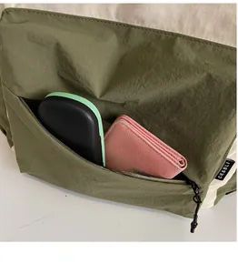 Close-up of olive green nylon bag featuring external zipper pocket and large capacity