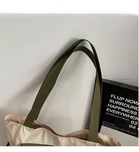 Close-up of olive green handles with sturdy stitching on minimalist canvas tote bag