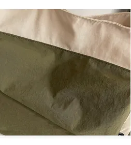Close-up of the beige and olive green canvas bag with textured fabric and stitching