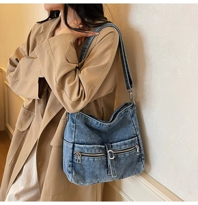 Macro detail of casual denim tote bag showing metal zippers and textured fabric