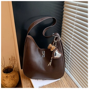 Detailed view of dark brown crescent hobo bag with leopard heart charm and silver buckle