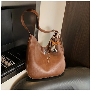 Detailed shot of dark brown retro bucket bag with silver lock and leopard bow accessory