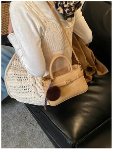 Détail du sac seau beige en cuir texturé avec boucle dorée et pendentif en peluche