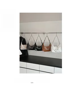 Cinq sacs à bandoulière minimalistes en similicuir de différentes couleurs sur des crochets