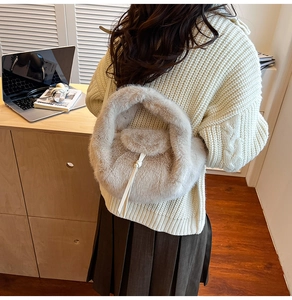 Détail de la texture en fausse fourrure et du cordon d'un sac à main en peluche beige