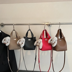 Detailed array of leather bucket bags in four colors with plush bunny charms