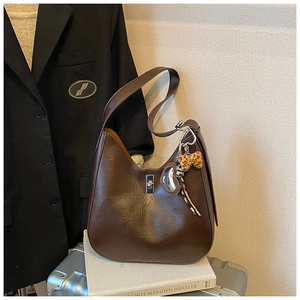 Detail of vintage caramel hobo bag featuring glossy textured faux leather and a twist lock
