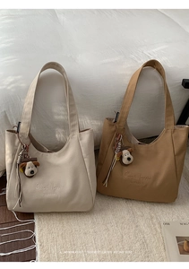 Minimalist canvas tote bags in cream and khaki with C'est la vie embroidery and dog charm