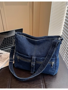 Large dark blue denim tote bag with silver zippers and contrast stitching on leather surface