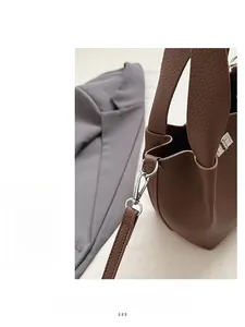 Detail of dark brown pebble leather bag with polished silver buckle and shoulder strap