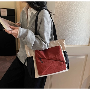 Detail of color-block nylon tote bag with drawstring pockets and zipper compartment